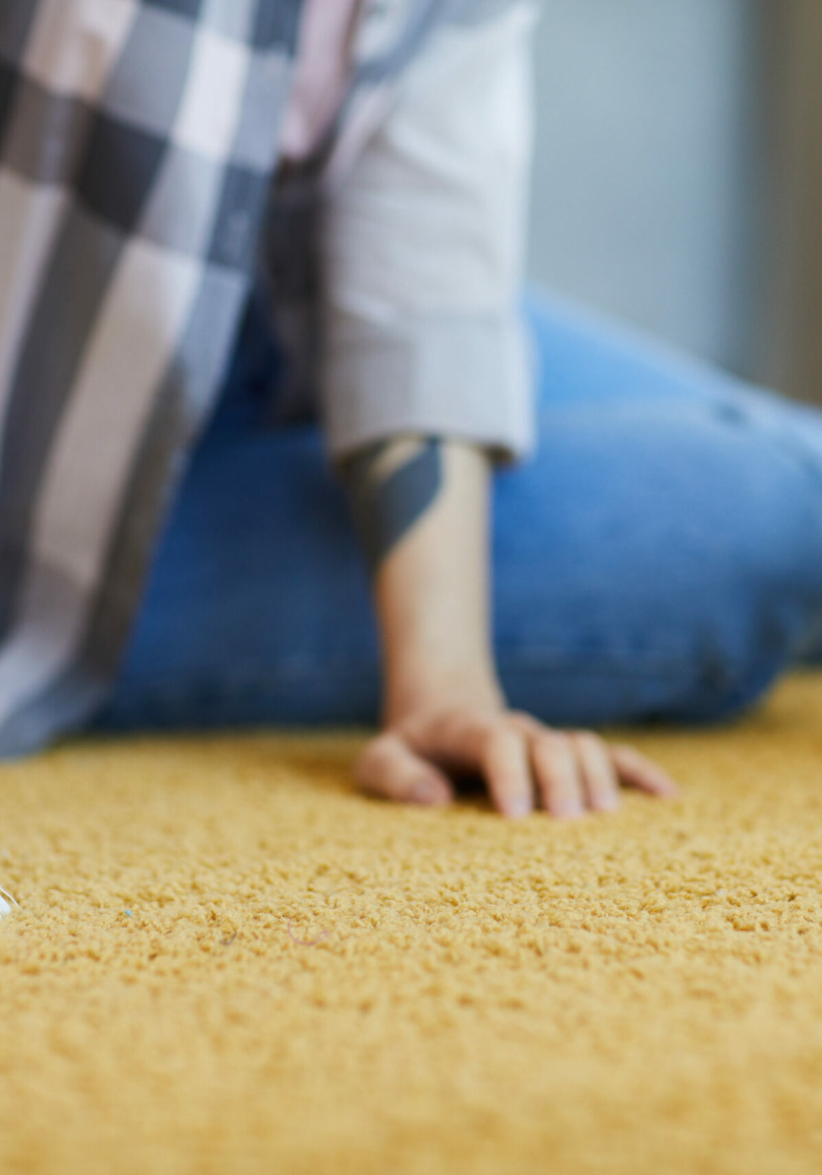 Close-up of housekeeper sitting on the floor and washing the carpet with brush at home